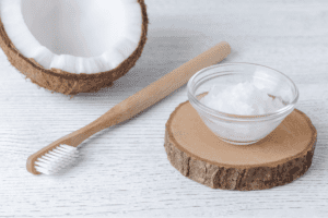 A image of a toothbrush and oil kept in a bowl used for oil pulling