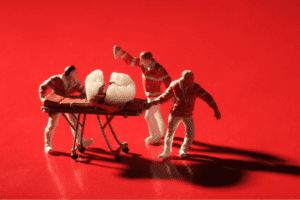 An image of three toy men taking a broken tooth on a bed