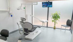 A dental room with a chair and a television.